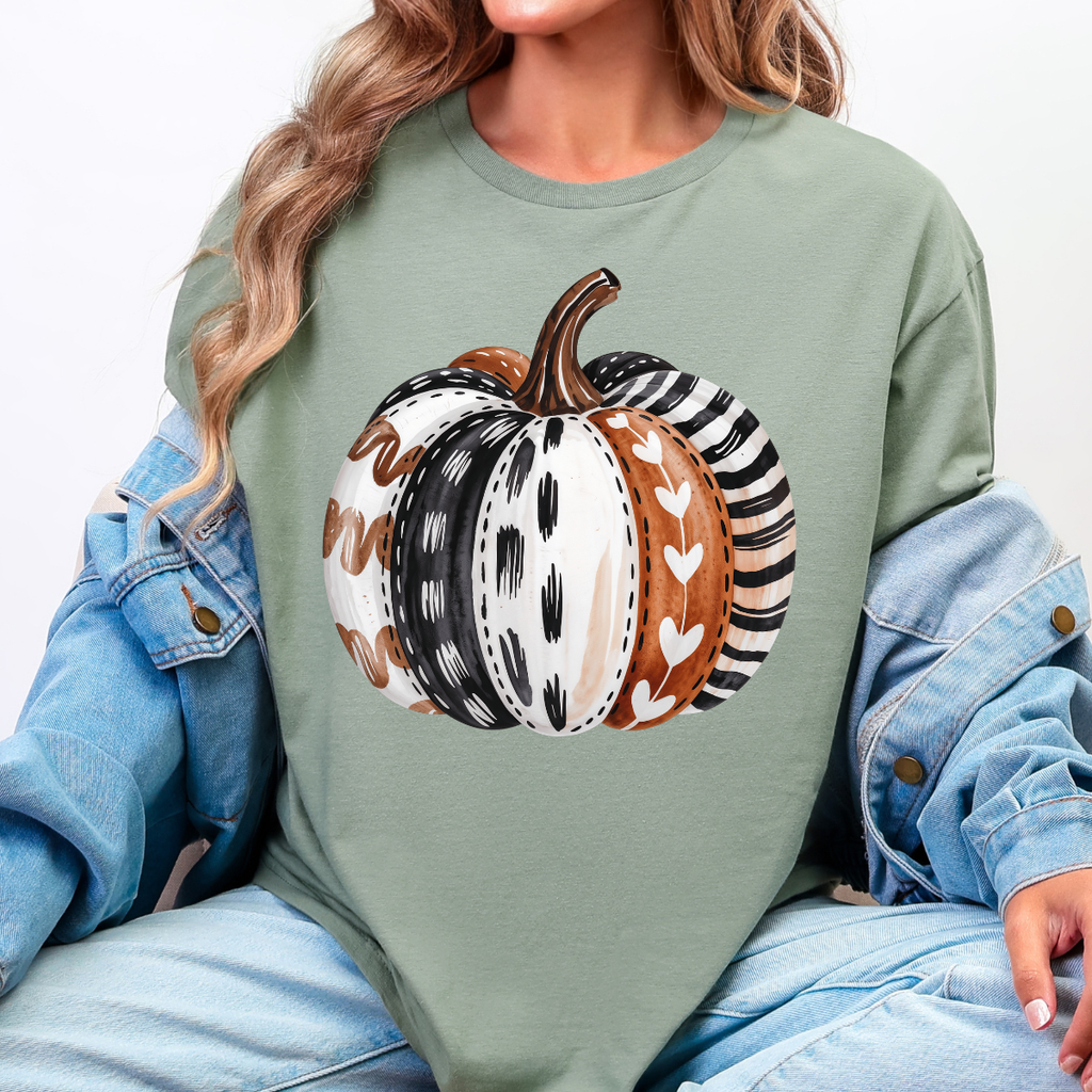 Woman wearing a sage green patterned pumpkin fall graphic tee with a neutral boho pumpkin design