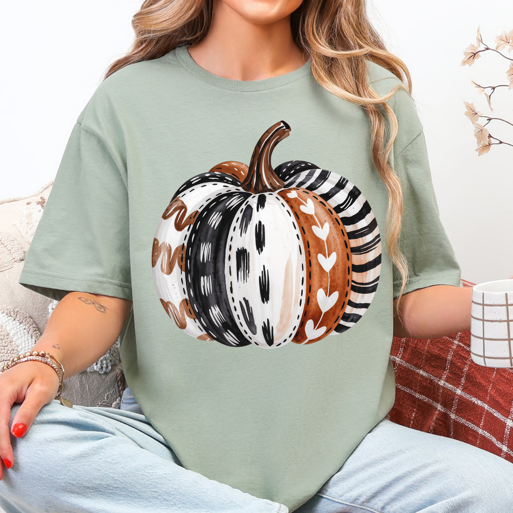 Woman wearing a sage green patterned pumpkin fall graphic tee with a neutral boho pumpkin design.