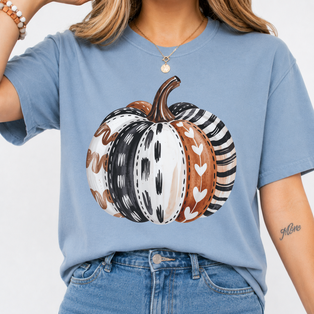 Woman wearing a stone blue patterned pumpkin fall graphic tee with a neutral boho pumpkin design