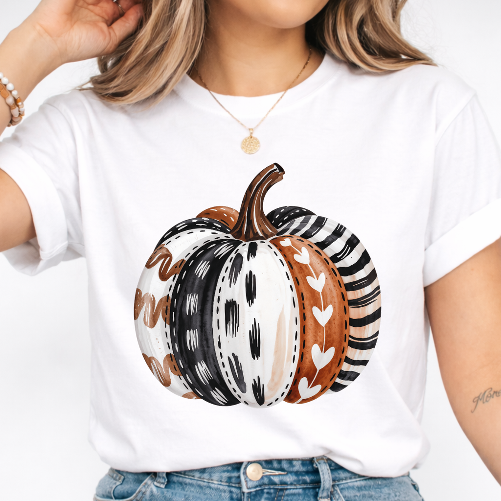 Woman wearing a white patterned pumpkin fall graphic tee with a neutral boho pumpkin design