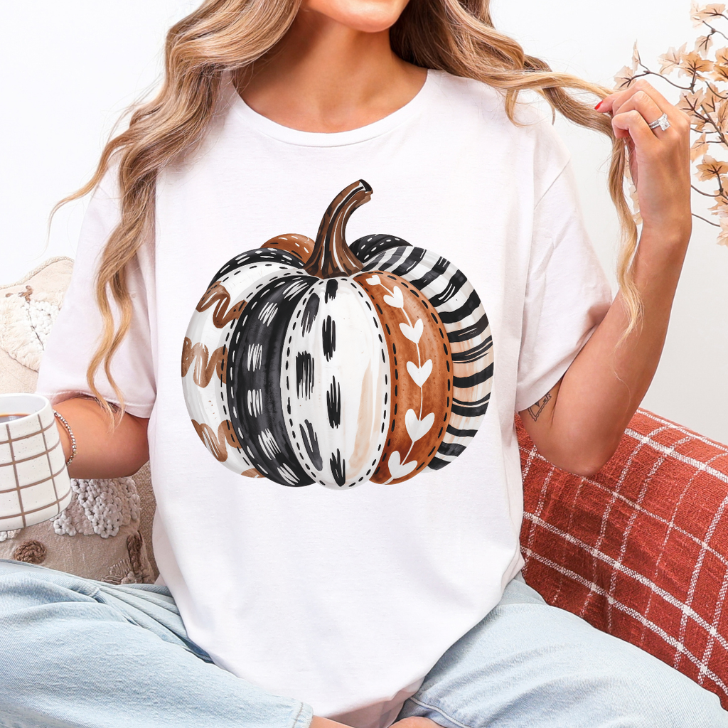 Woman wearing a white patterned pumpkin fall graphic tee with a neutral boho pumpkin design.