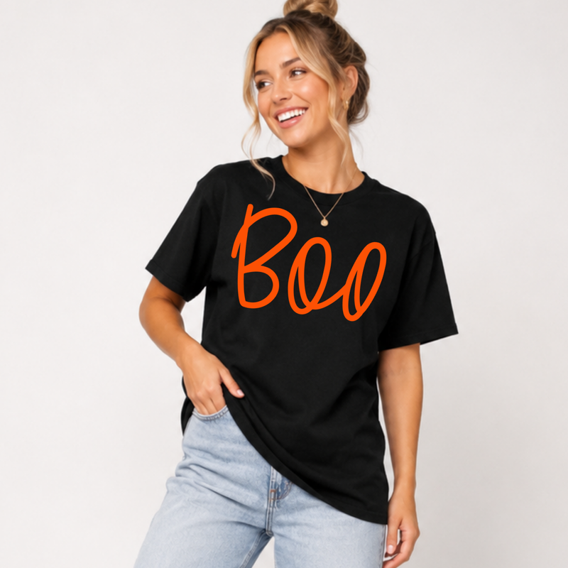 Woman wearing a black Boo Halloween graphic tee with oversized orange script lettering.