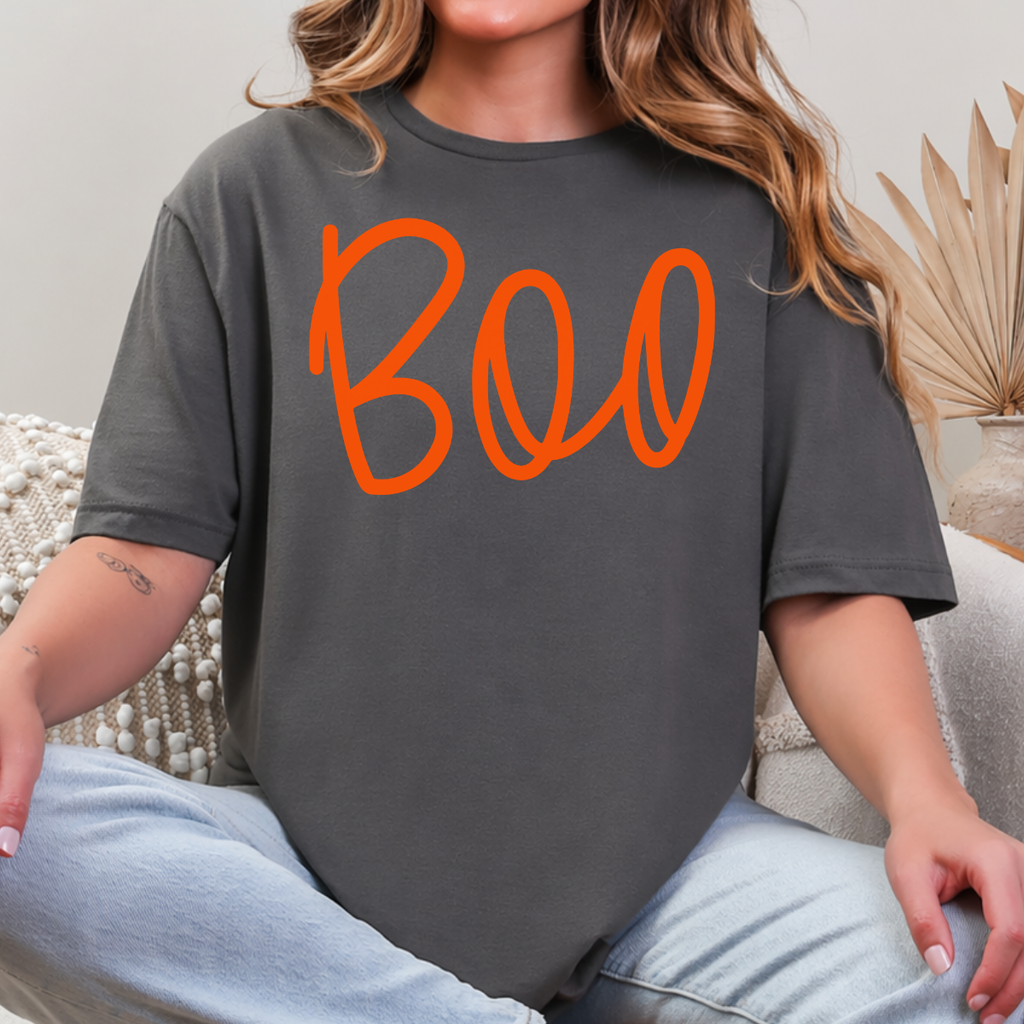 Woman wearing a charcoal Boo Halloween graphic tee with oversized orange script lettering.