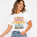 Woman wearing a white Deviled Eggs and Family Drama Thanksgiving graphic tee with colorful lettering and deviled egg illustrations.