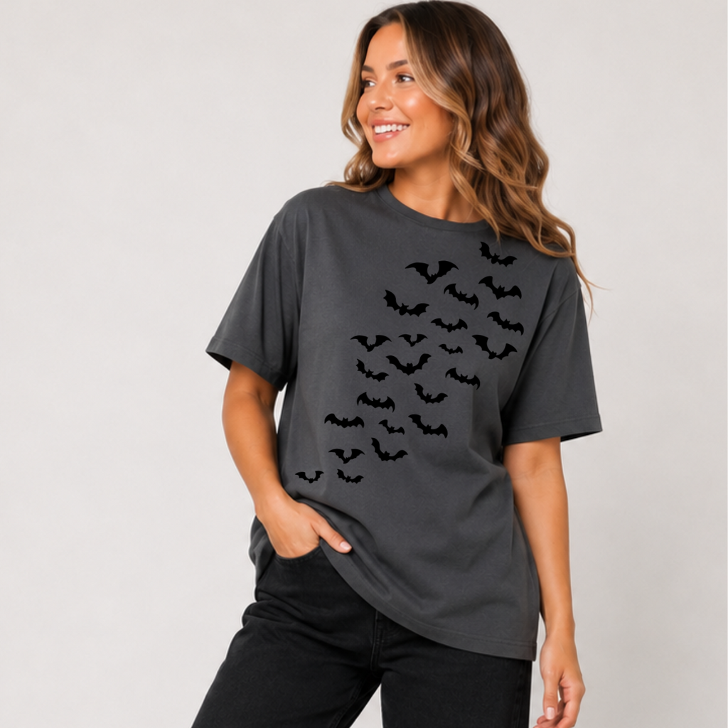 Woman wearing a charcoal Halloween graphic tee with cascading black bats across the front.
