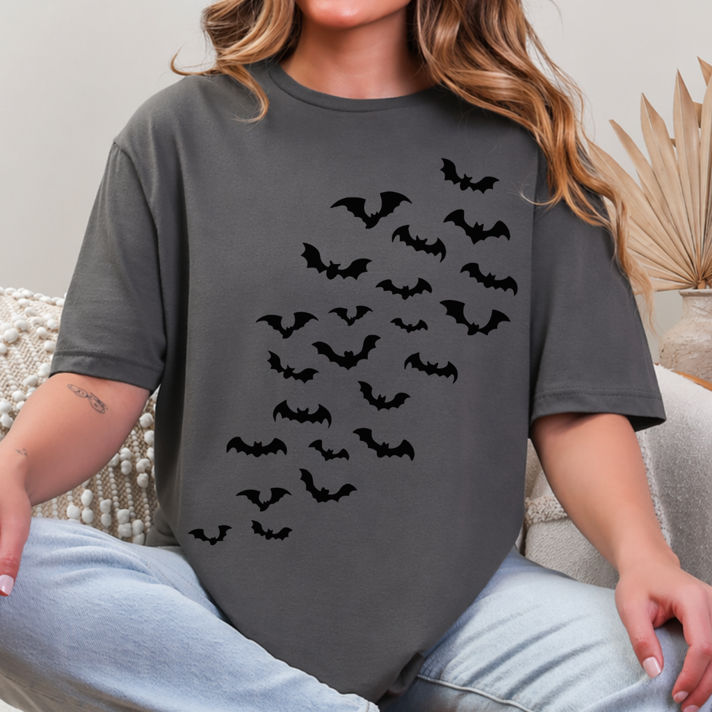 Woman wearing a charcoal Halloween graphic tee with cascading black bats across the front.