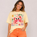 Woman wearing a yellow t-shirt with a colorful graphic design on a plain background