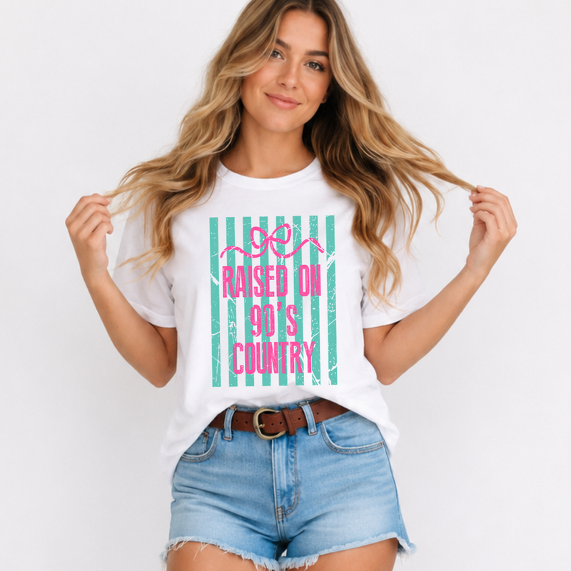 Woman wearing a white t-shirt with 'Raised on 90's Country' design, standing against a plain background.
