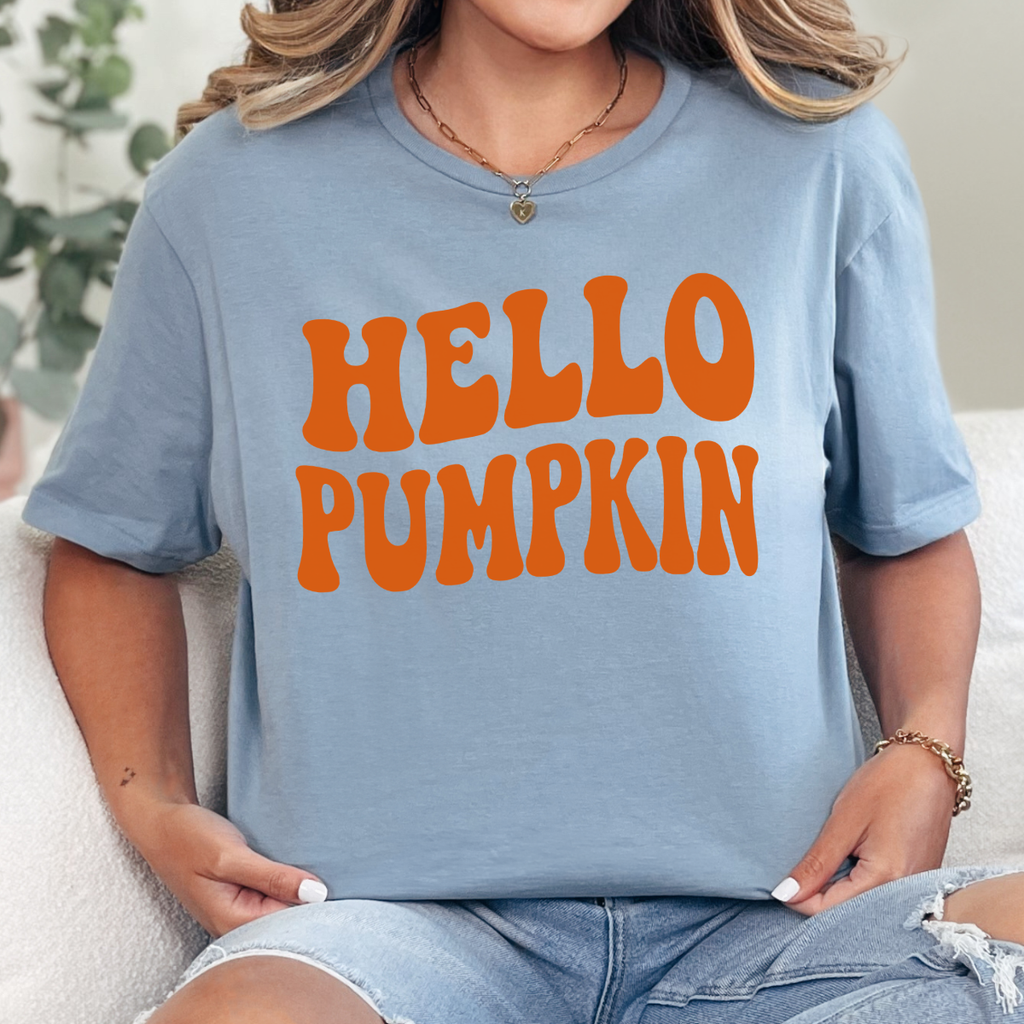 Woman wearing a stone blue Hello Pumpkin fall graphic tee with bold orange retro lettering.