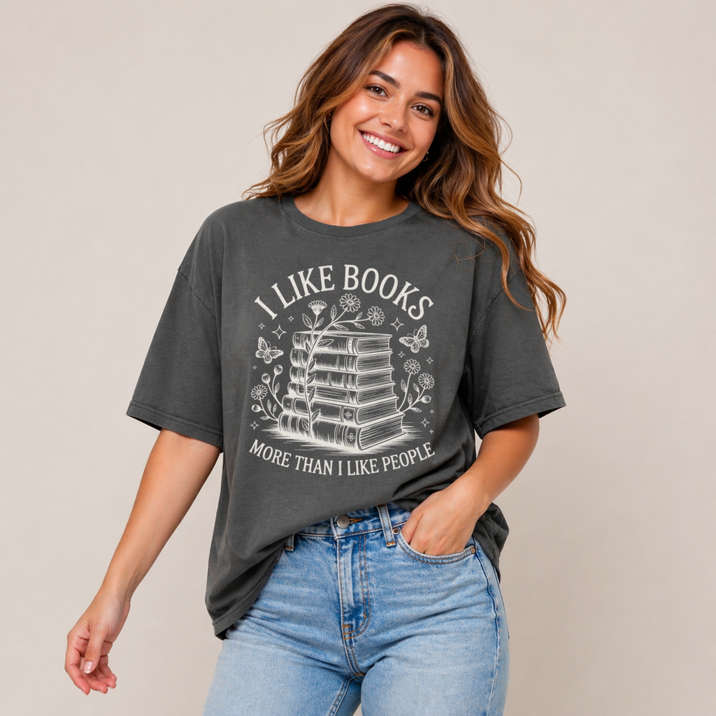 Woman wearing a dark gray t-shirt with a book-themed design and text, standing against a plain background.
