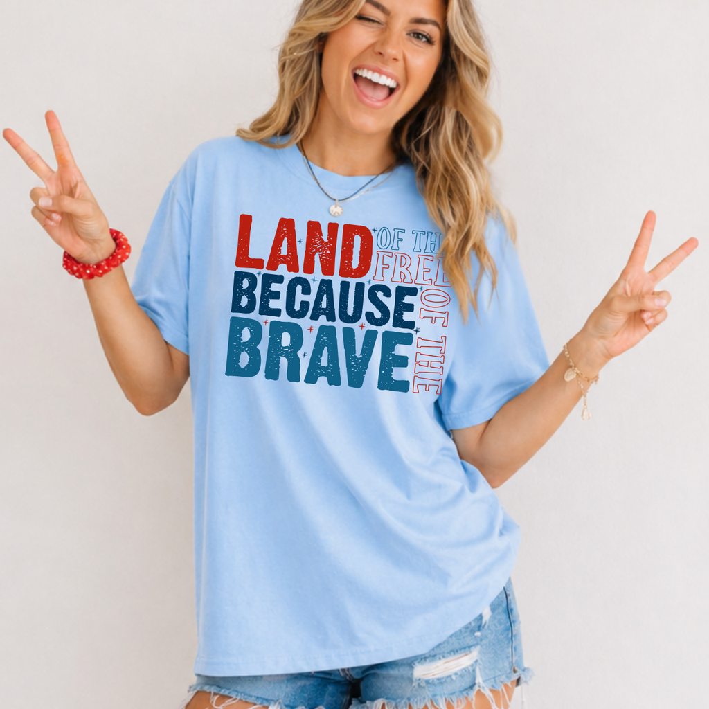 Woman wearing a light blue t-shirt with patriotic text, making peace signs.