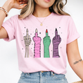 Woman wearing a light pink Halloween graphic tee with colorful skeleton, monster, witch, and mummy middle finger hands.