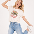 Woman wearing a t-shirt with a floral design and text, standing against a white background