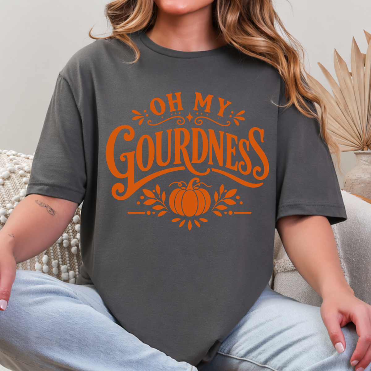 Woman wearing a charcoal Oh My Gourdness fall graphic tee with orange lettering and a pumpkin design