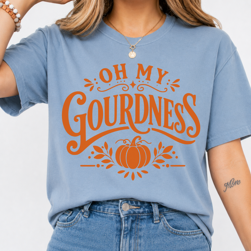 Woman wearing a stone blue Oh My Gourdness fall graphic tee with orange lettering and a pumpkin design.