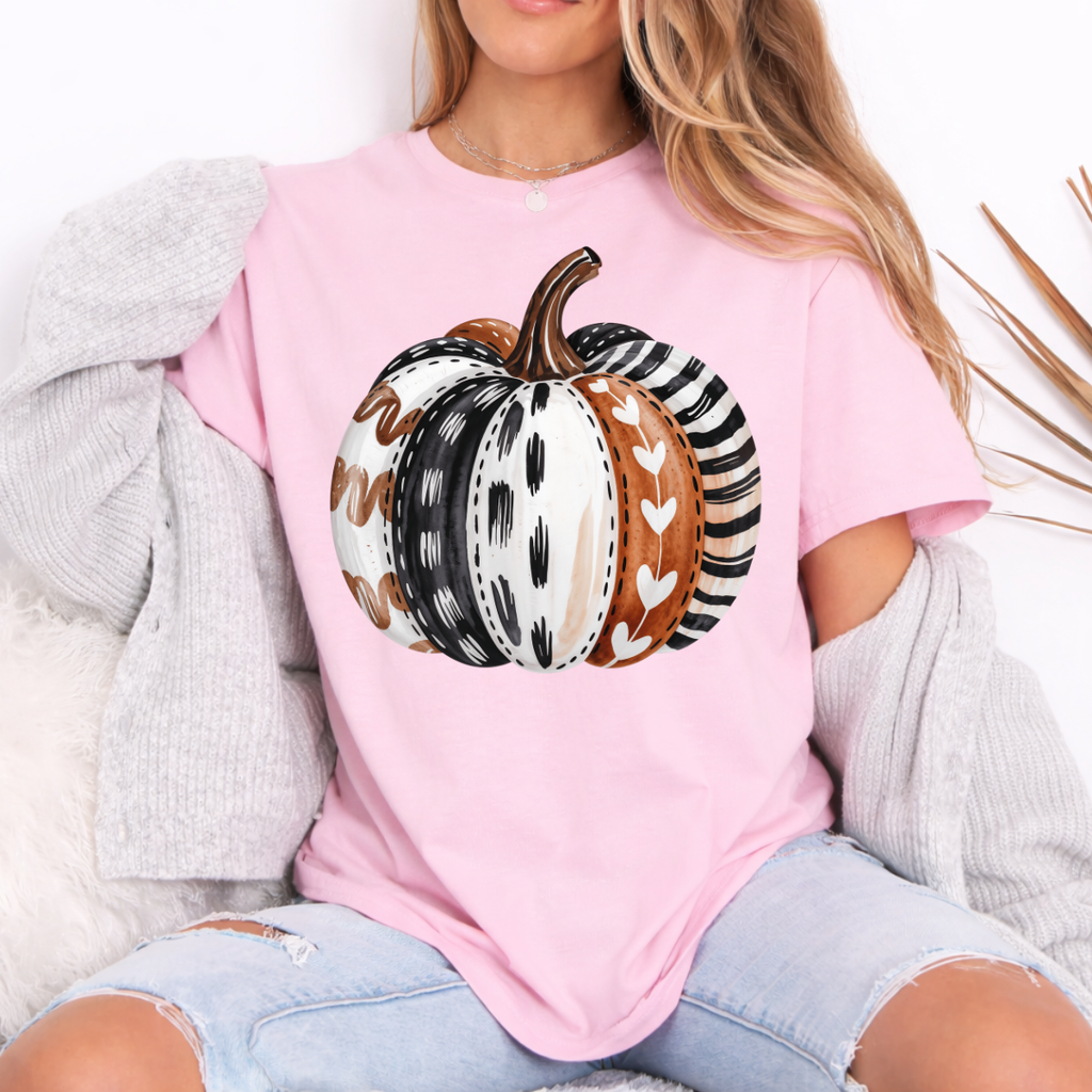 Woman wearing a light pink patterned pumpkin fall graphic tee with a neutral boho pumpkin design.
