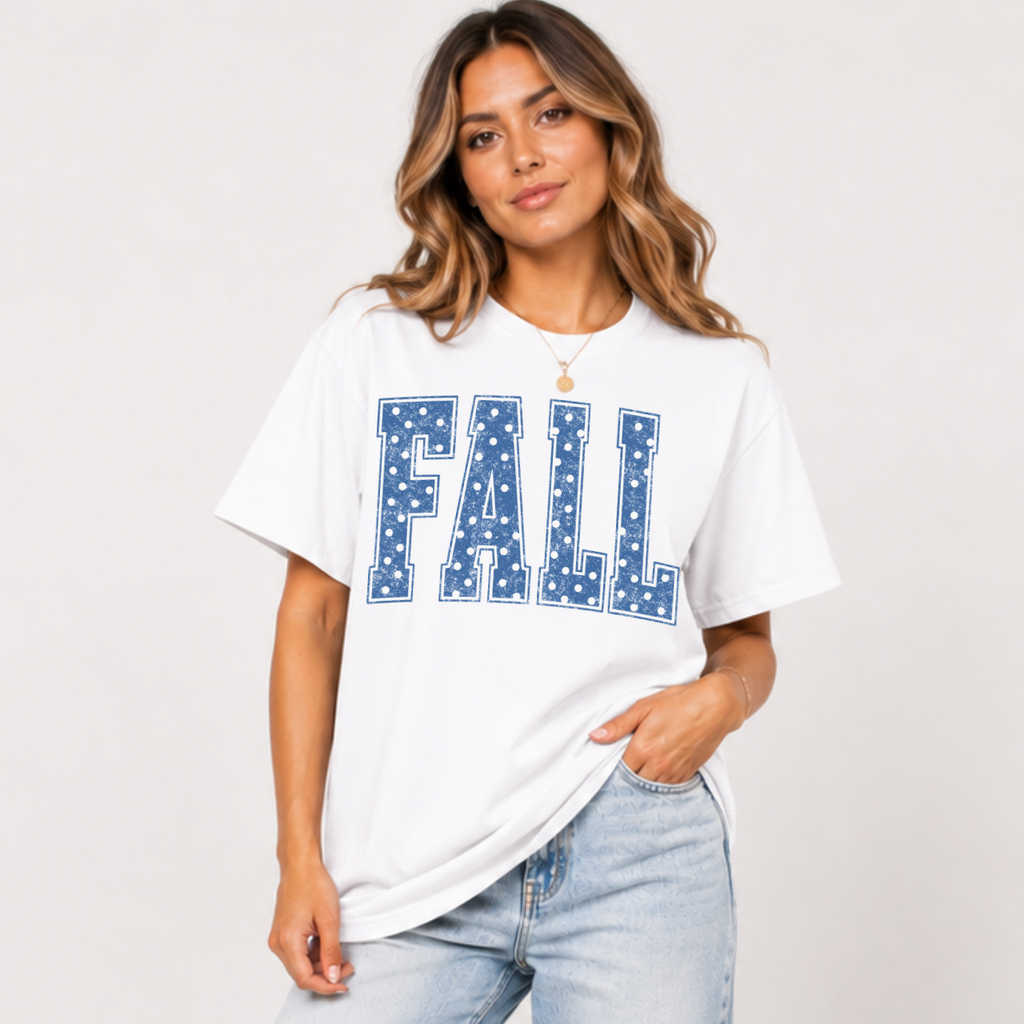 Woman wearing a white Fall graphic tee with blue polka dot collegiate lettering.