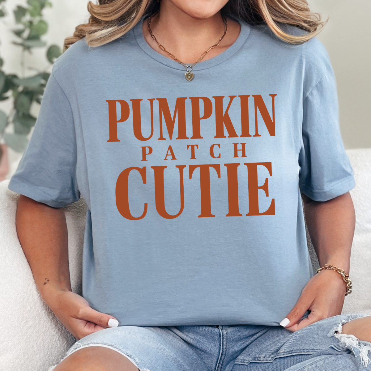 Woman wearing a stone blue Pumpkin Patch Cutie fall graphic tee with rust orange lettering.