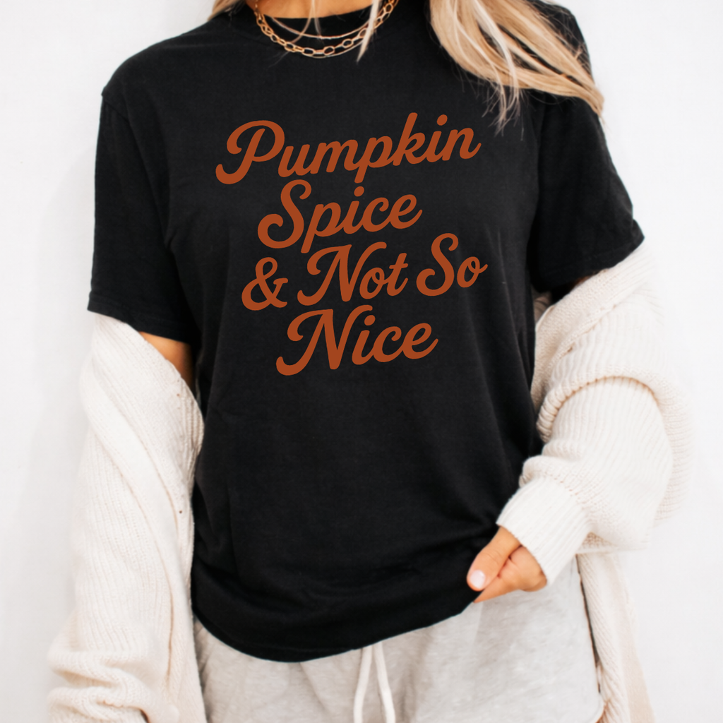 Woman wearing a black Pumpkin Spice and Not So Nice fall graphic tee with rust orange script lettering.