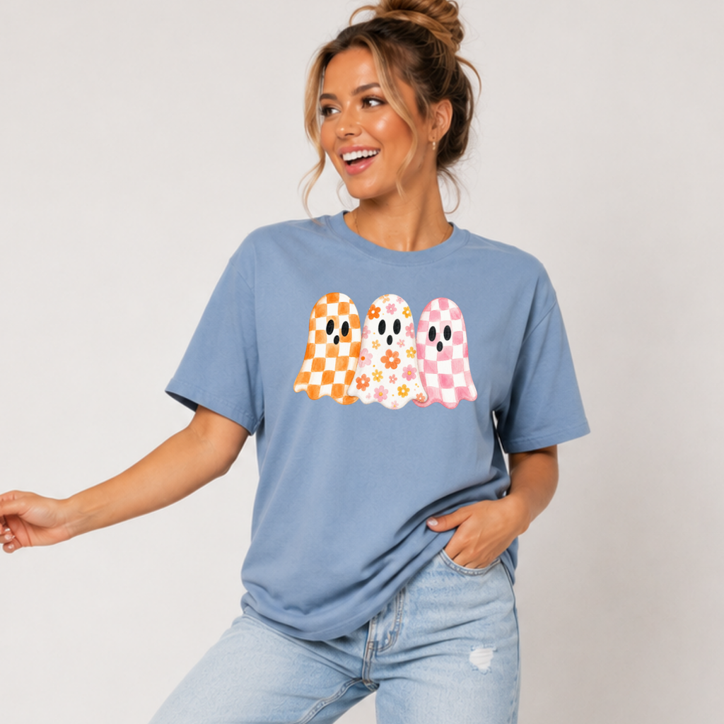 Woman wearing a stone blue Halloween graphic tee with three orange, floral, and pink patterned ghosts.