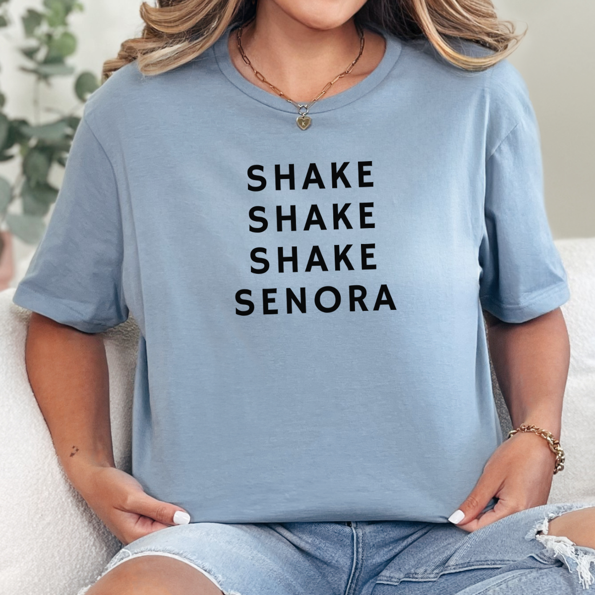 Woman wearing a stone blue Shake Shake Shake Señora Halloween graphic tee with black lettering.