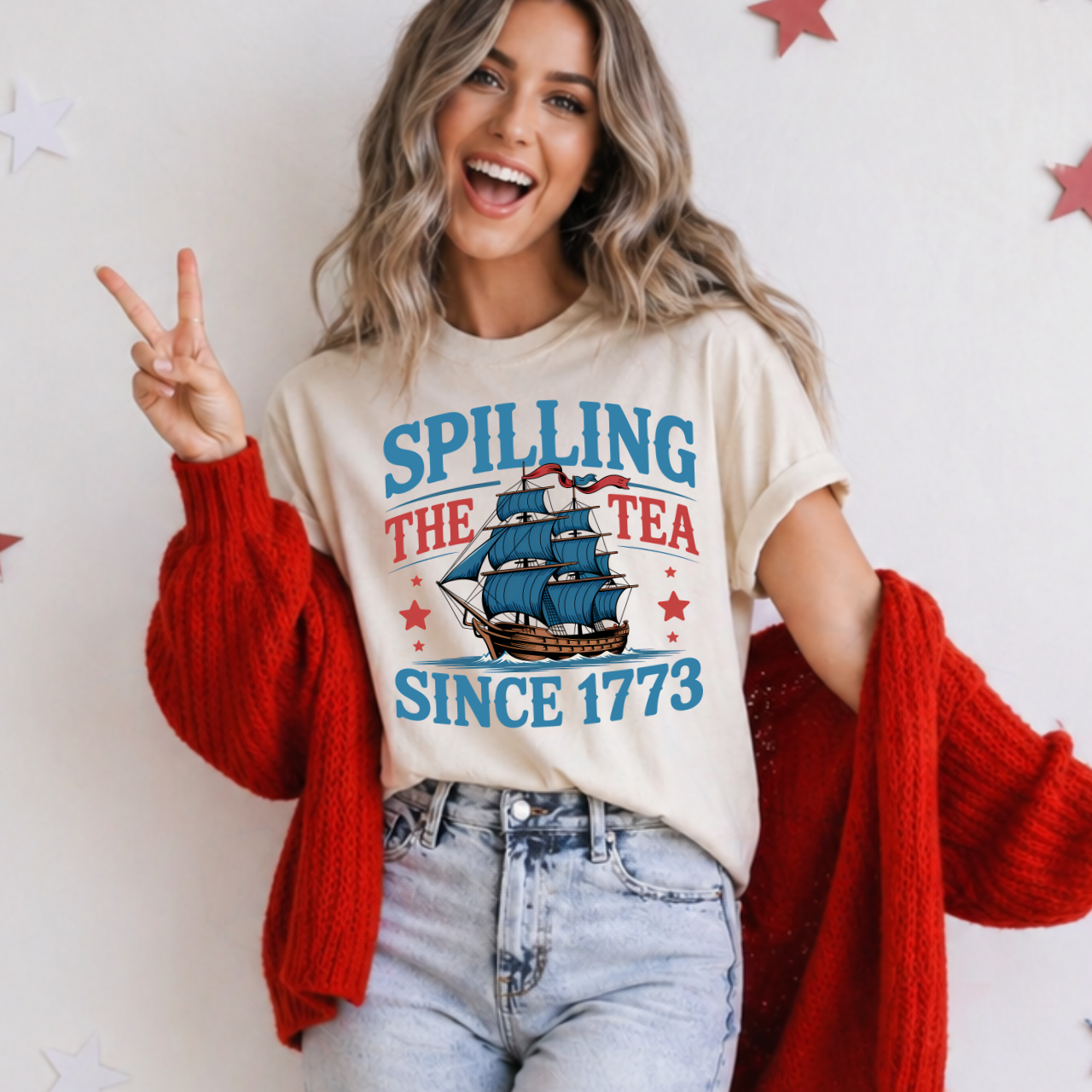 Woman wearing a t-shirt with a ship graphic and text, standing against a white background.