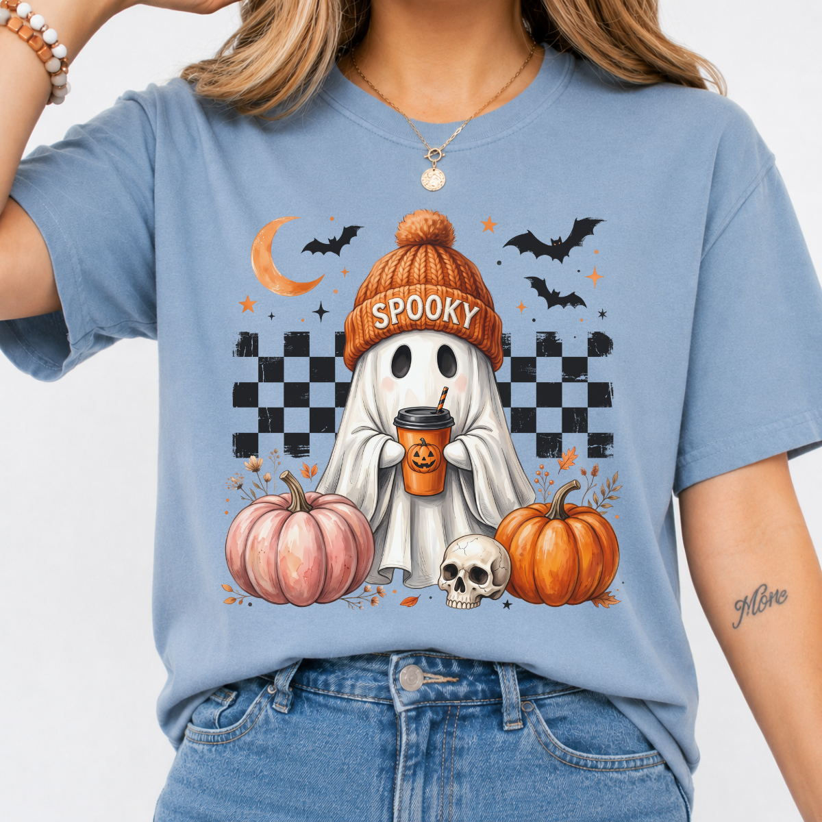 Woman wearing a blue spooky ghost pumpkin coffee graphic tee with pumpkins, bats, and a ghost