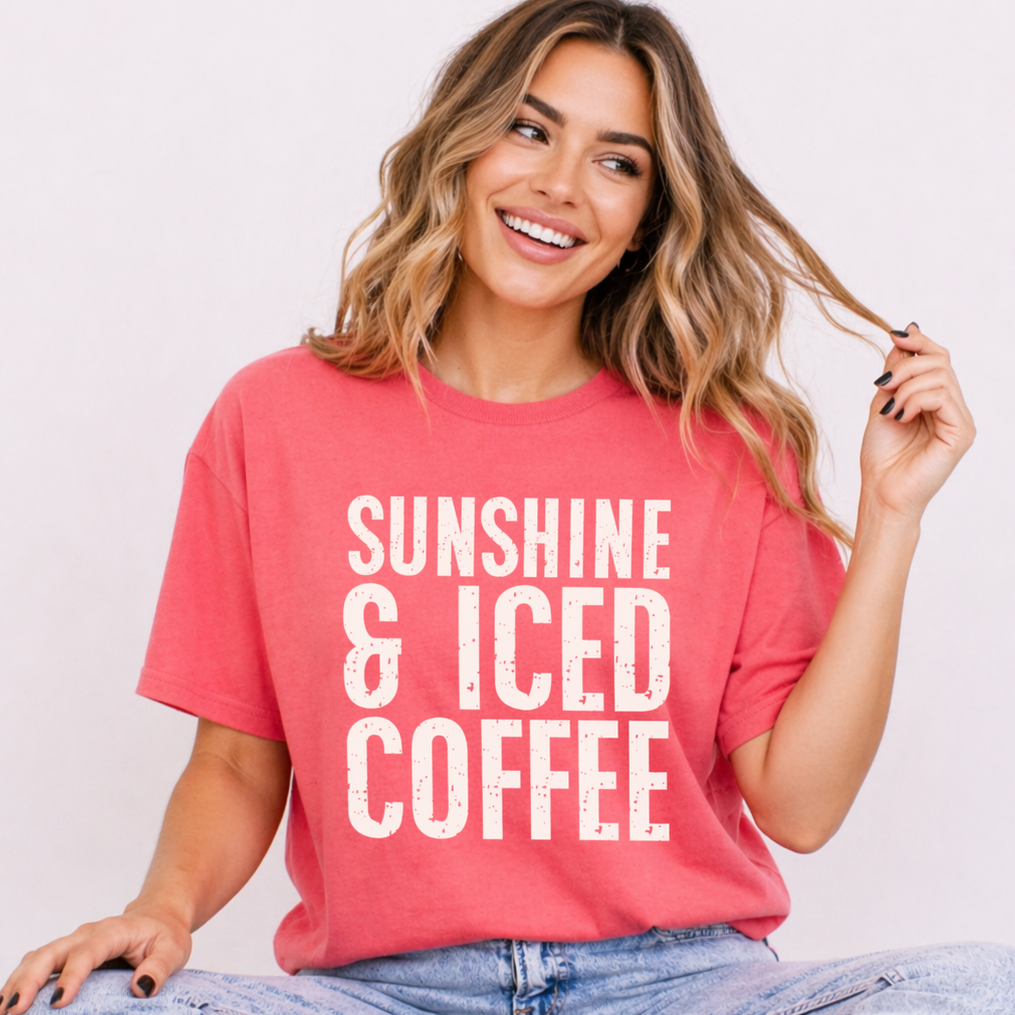 Woman wearing a pink t-shirt with 'Sunshine & Iced Coffee' text on a plain background