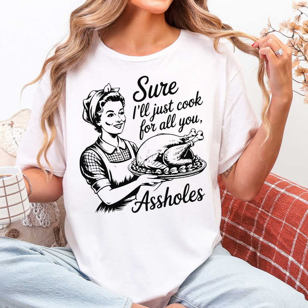 Woman wearing a white funny Thanksgiving graphic tee with a retro hostess holding a roasted turkey.