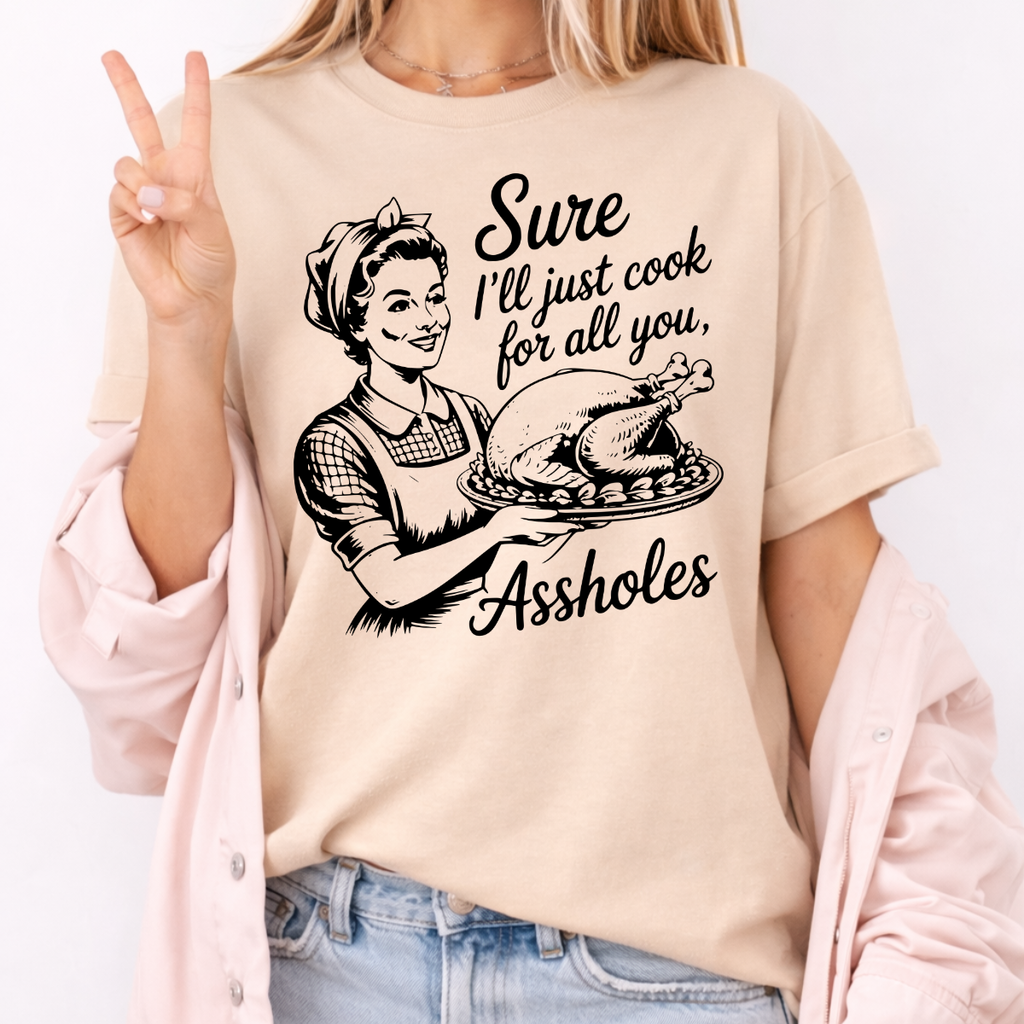 Woman wearing a sand funny Thanksgiving graphic tee with a retro hostess holding a roasted turkey