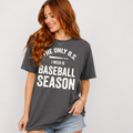 Woman wearing a gray t-shirt with a humorous baseball season quote that says "The Only B.S. I need is Baseball Season".